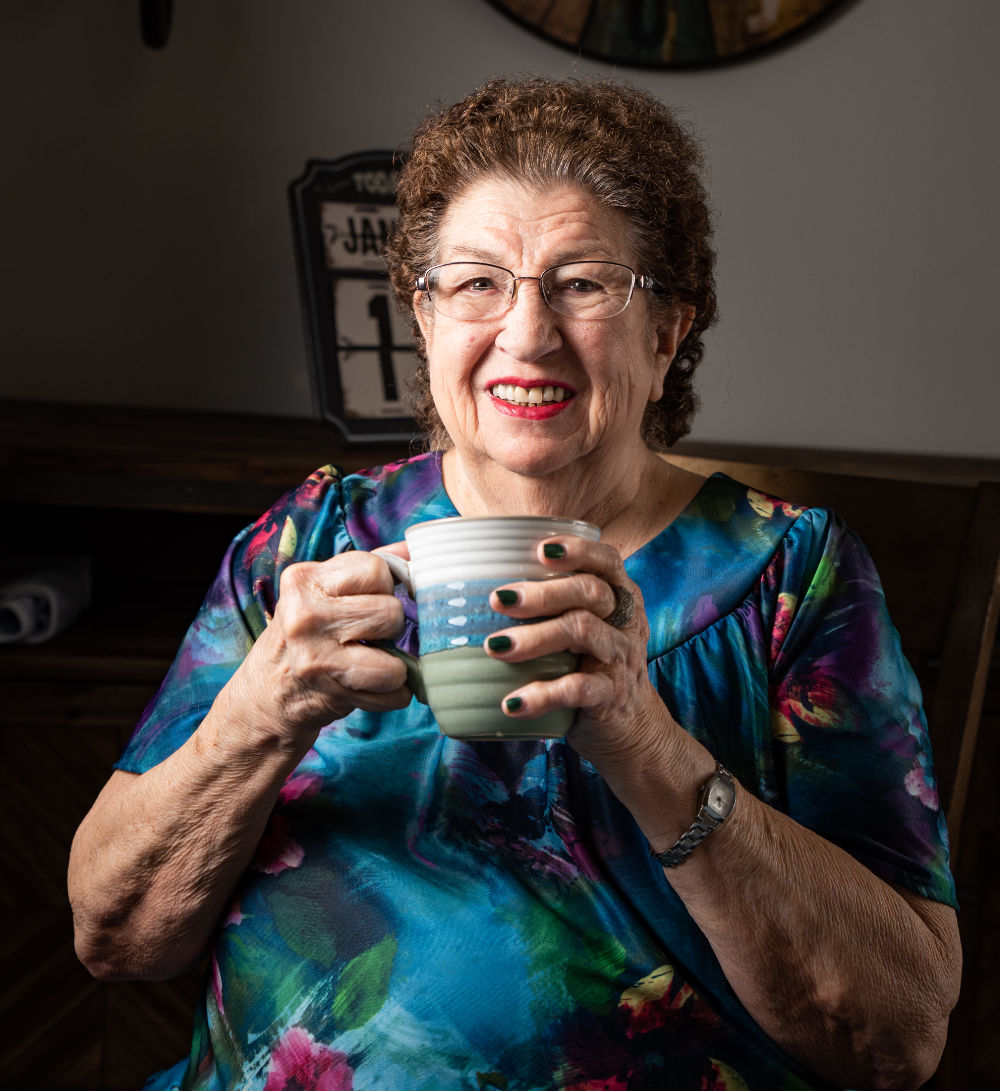 Smiling Resident holding a cup of liquid